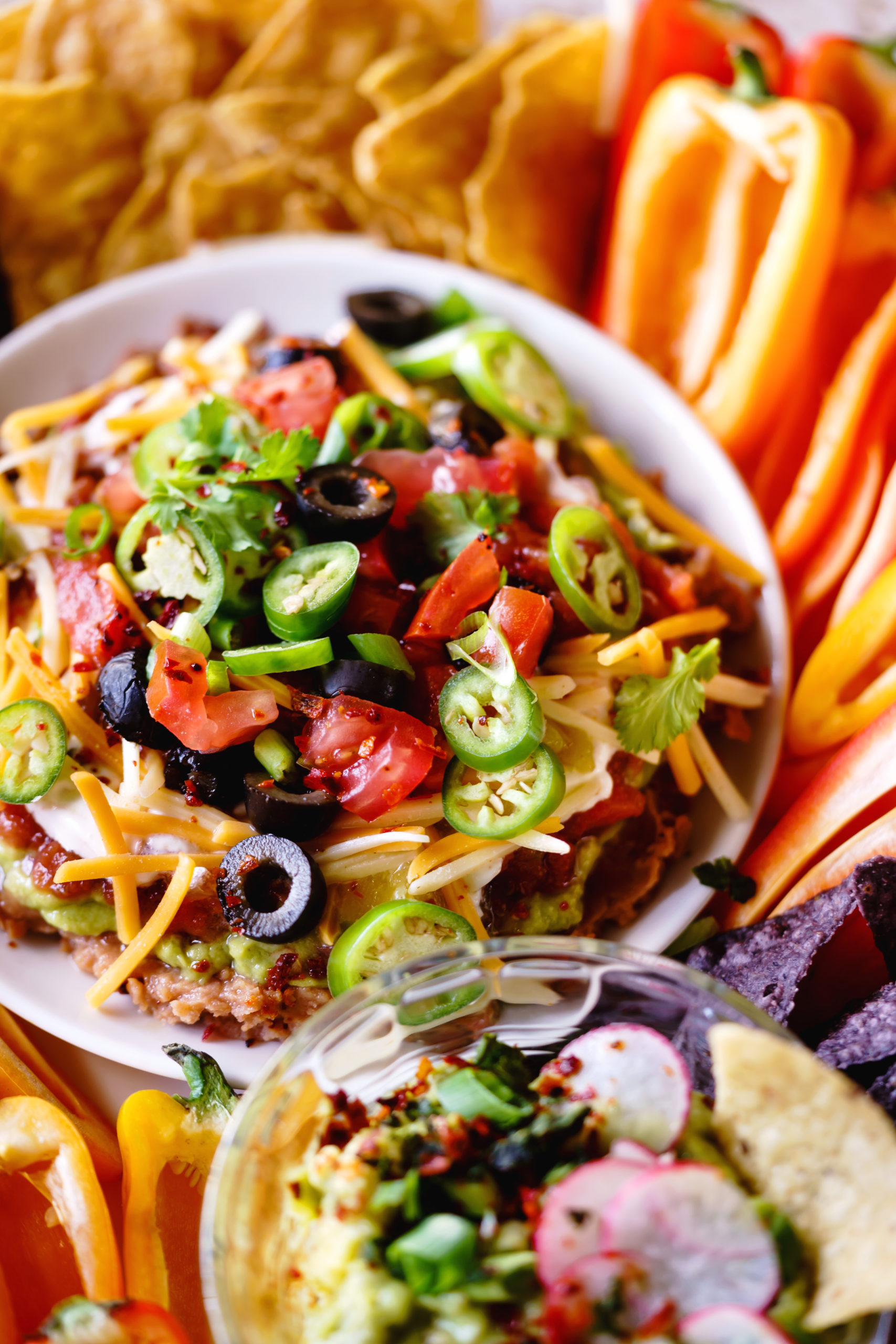 Seven-Layer Dip served with chips and crispy veggies. 